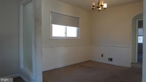 unfurnished room with a chandelier