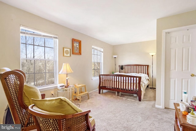 bedroom featuring light colored carpet and multiple windows