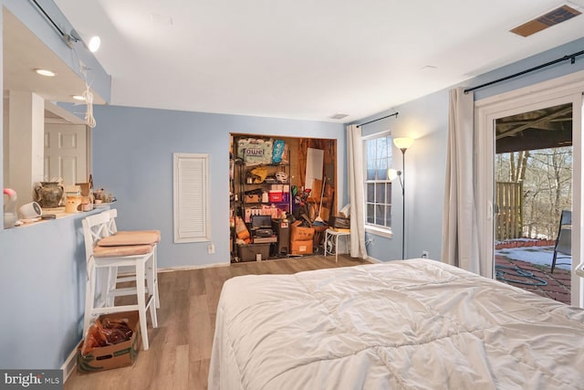 bedroom with hardwood / wood-style flooring and access to exterior