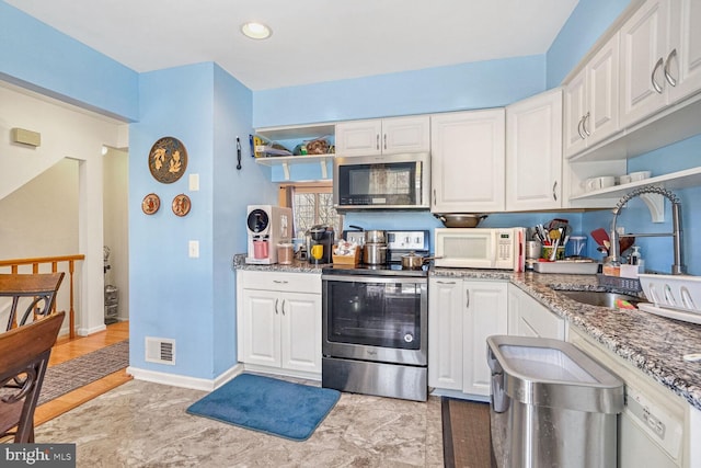 kitchen featuring white cabinetry, appliances with stainless steel finishes, sink, and dark stone counters