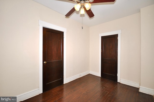 spare room with dark hardwood / wood-style flooring and ceiling fan