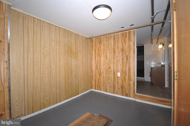 unfurnished room featuring wood walls