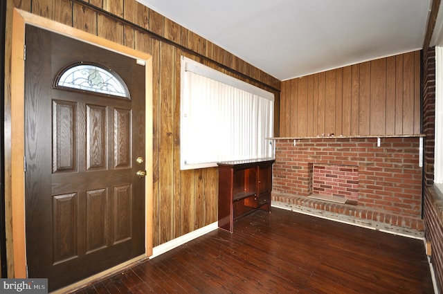 foyer with dark hardwood / wood-style flooring, a wealth of natural light, and wooden walls