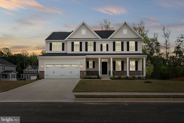 view of front of home featuring a garage, covered porch, and a lawn