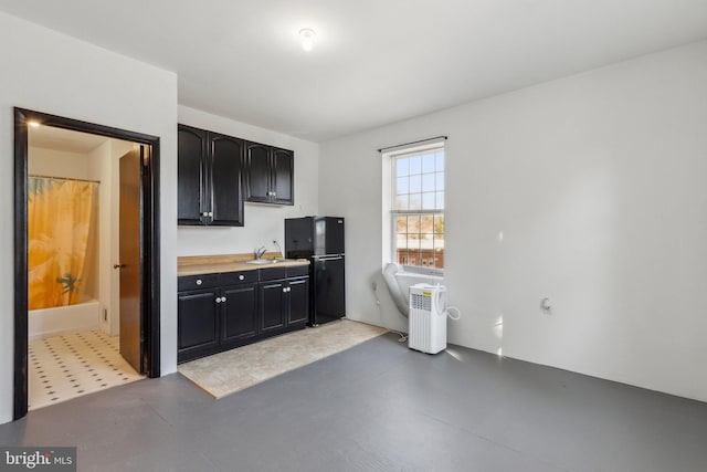 kitchen with black refrigerator and sink