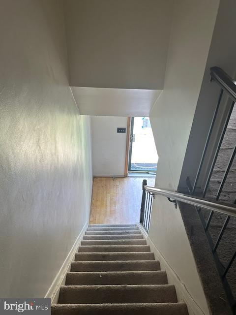 stairs featuring hardwood / wood-style floors