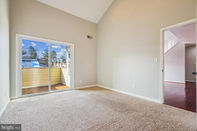 carpeted empty room featuring high vaulted ceiling