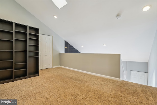 additional living space with carpet flooring and vaulted ceiling with skylight