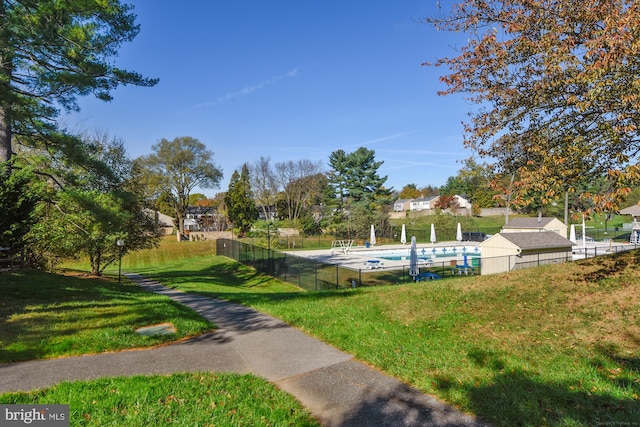 view of community with a yard and a swimming pool