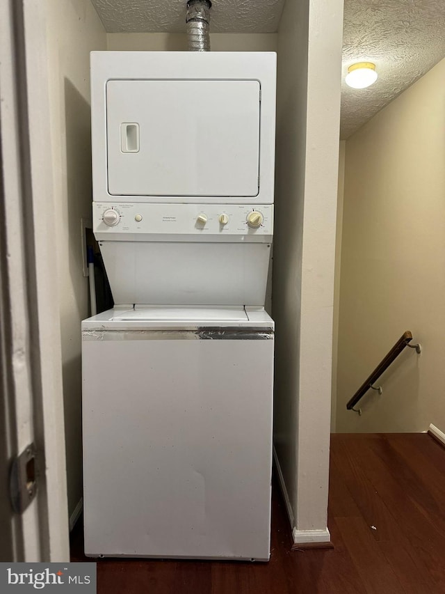 laundry room with stacked washer and dryer and a textured ceiling