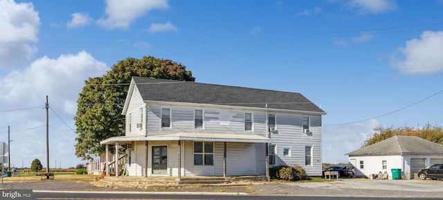 view of front of home featuring a porch, a garage, and an outdoor structure