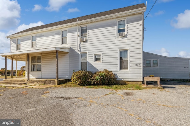 rear view of house featuring cooling unit and a porch