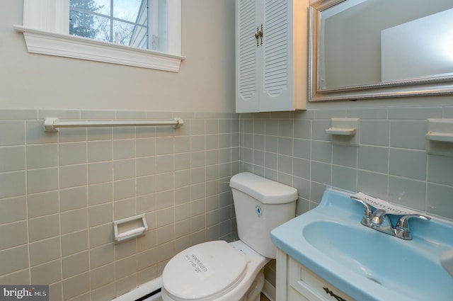 bathroom with vanity, toilet, and tile walls