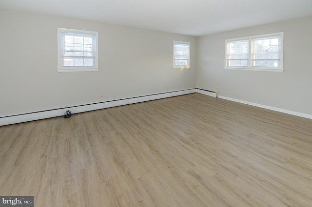 spare room featuring a baseboard radiator and light hardwood / wood-style floors