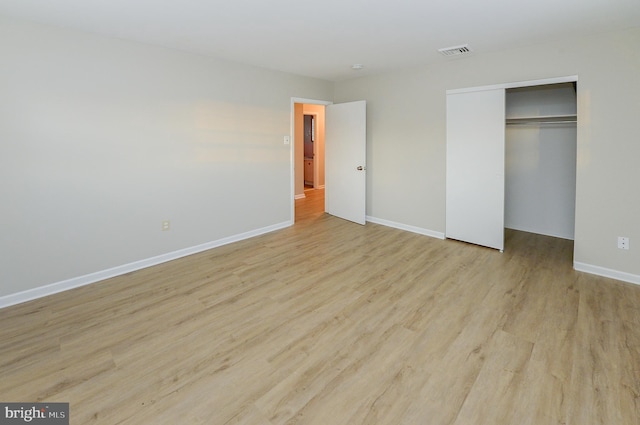 unfurnished bedroom with a closet and light wood-type flooring