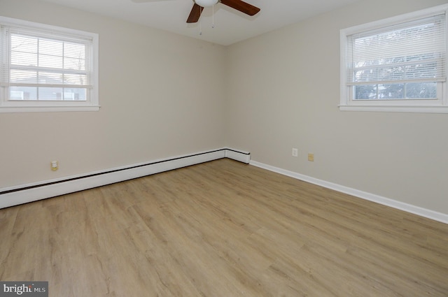 empty room featuring a baseboard heating unit, ceiling fan, and light wood-type flooring