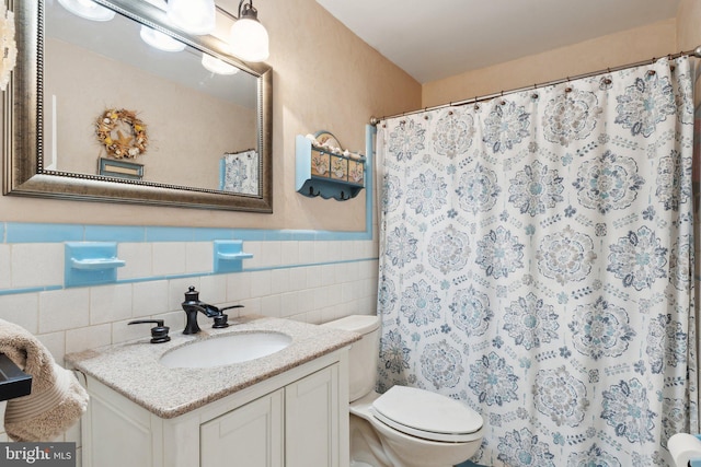 bathroom with vanity, a shower with curtain, toilet, and tile walls