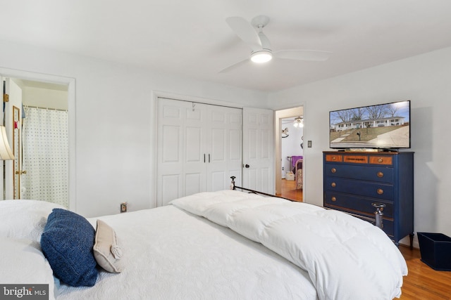 bedroom with wood-type flooring, ensuite bathroom, ceiling fan, and a closet