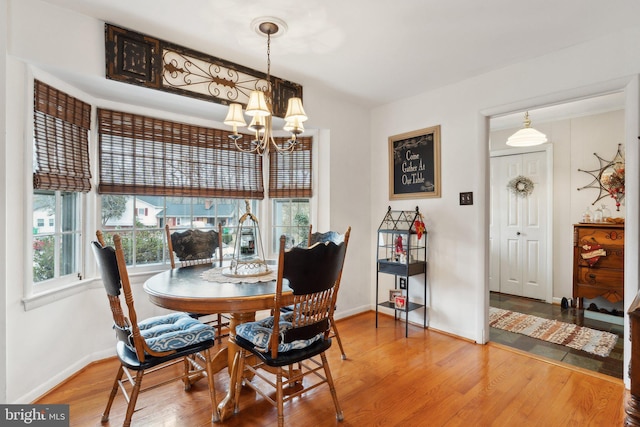 dining space with wood-type flooring and a chandelier