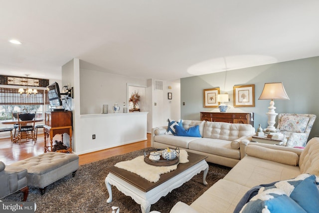 living room with an inviting chandelier and wood-type flooring