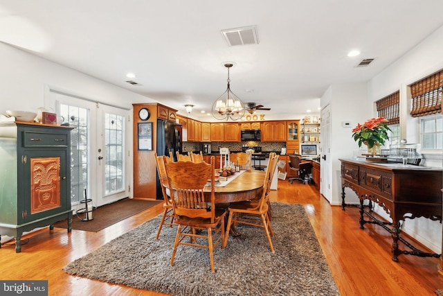 dining space featuring french doors, light hardwood / wood-style flooring, and a notable chandelier