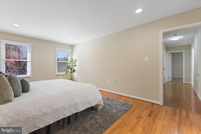 bedroom with recessed lighting, baseboards, and light wood-type flooring