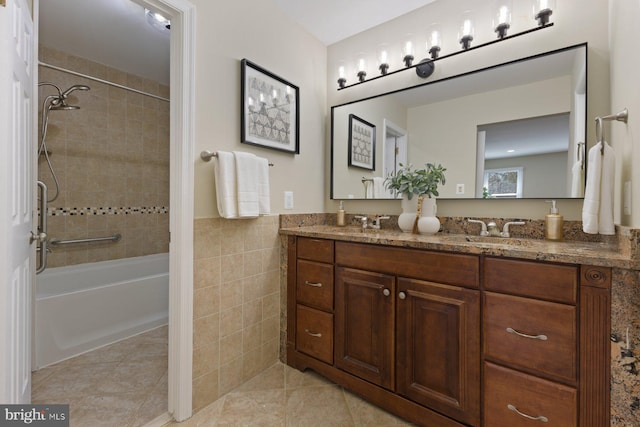bathroom featuring washtub / shower combination, tile patterned flooring, double vanity, a sink, and tile walls