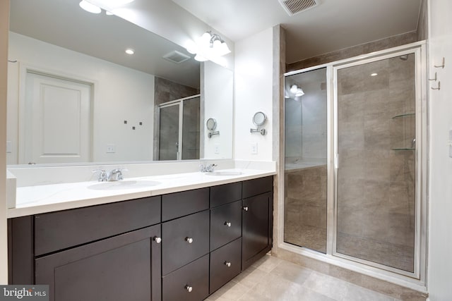 bathroom featuring vanity, a shower with shower door, and tile patterned floors