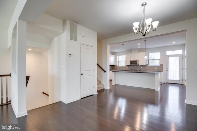 kitchen featuring a kitchen island, dark wood-type flooring, white cabinets, and decorative light fixtures