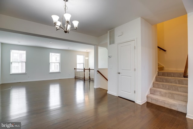 interior space featuring dark wood-type flooring and a notable chandelier