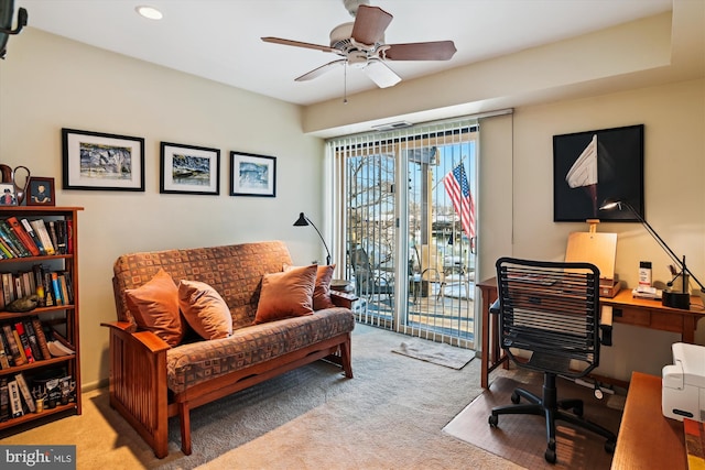 carpeted office space featuring ceiling fan