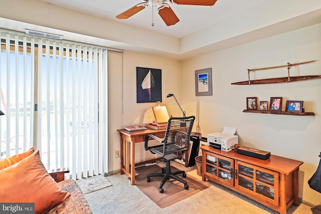 carpeted office space with ceiling fan