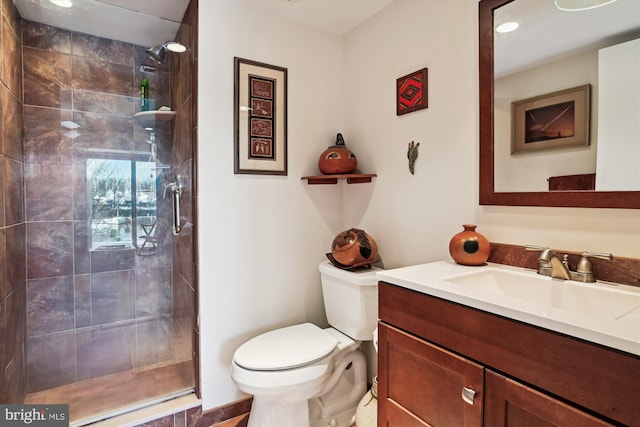 bathroom featuring vanity, toilet, and a tile shower