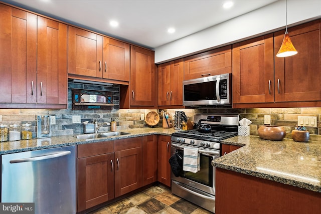 kitchen with sink, stone countertops, pendant lighting, stainless steel appliances, and backsplash