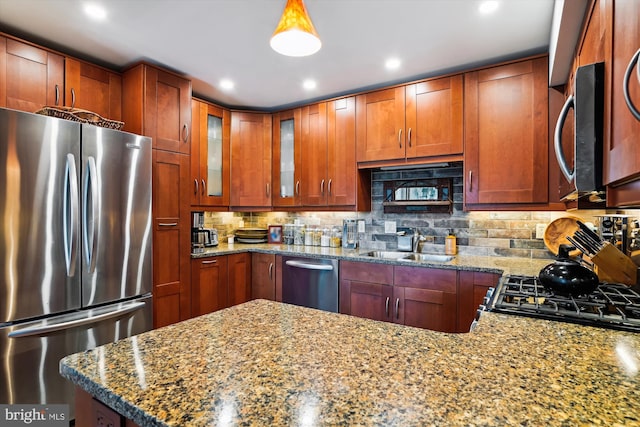 kitchen with tasteful backsplash, light stone countertops, stainless steel appliances, and sink