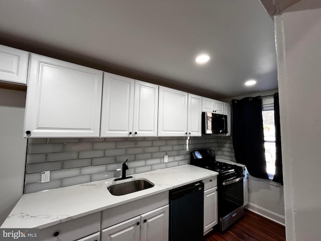 kitchen with sink, appliances with stainless steel finishes, backsplash, light stone countertops, and white cabinets