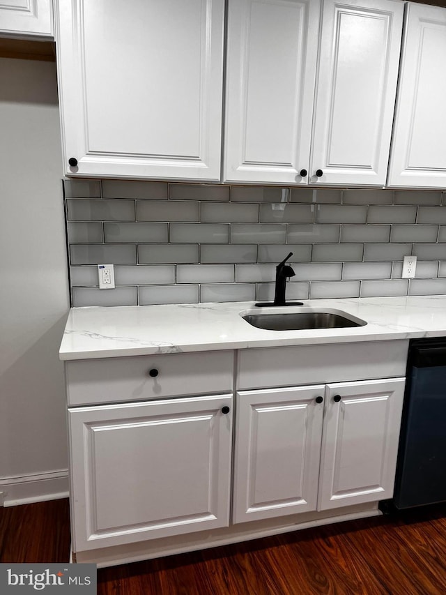 details featuring light stone counters, dishwasher, sink, and white cabinets