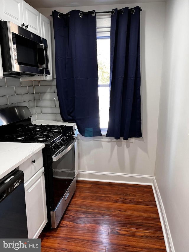 kitchen featuring white cabinetry, stainless steel appliances, dark wood-type flooring, and backsplash