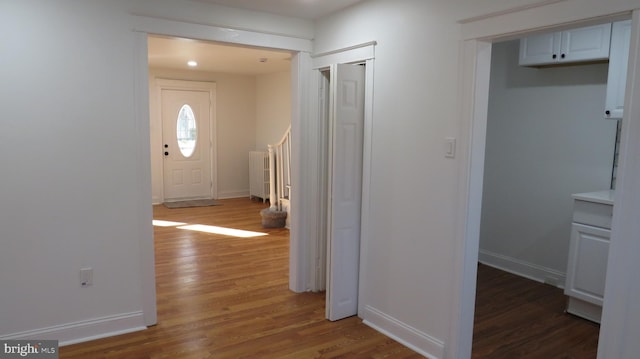 foyer entrance featuring dark hardwood / wood-style flooring and radiator heating unit