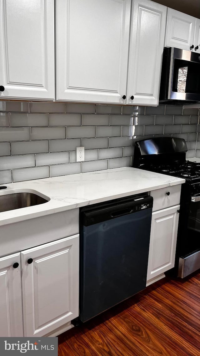 kitchen with black dishwasher, tasteful backsplash, light stone countertops, white cabinets, and gas range