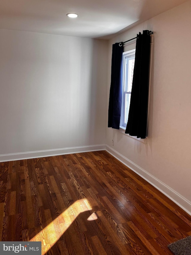 spare room with dark wood-type flooring