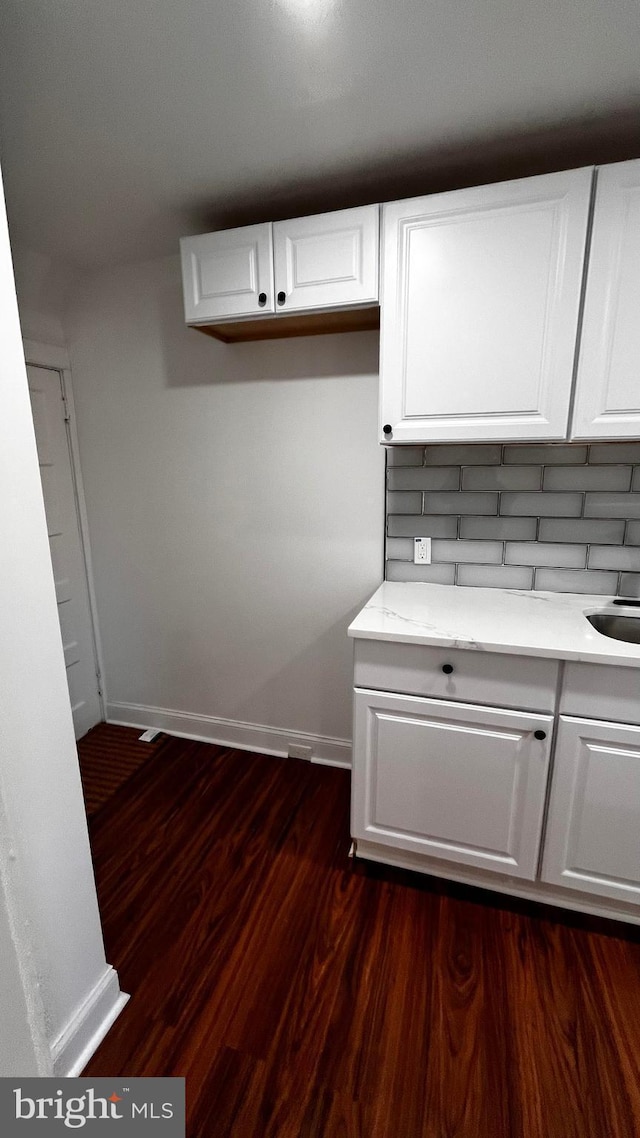 kitchen featuring white cabinets, dark hardwood / wood-style flooring, and decorative backsplash