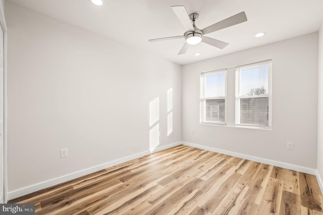 empty room with ceiling fan and light hardwood / wood-style flooring