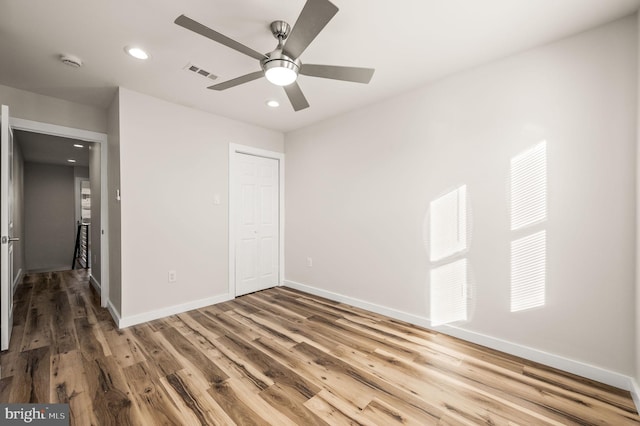 unfurnished bedroom with wood-type flooring, a closet, and ceiling fan