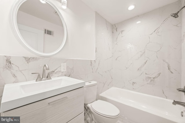 full bathroom featuring shower / tub combination, vanity, toilet, and tile walls