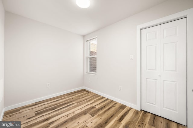 unfurnished bedroom with a closet and light wood-type flooring