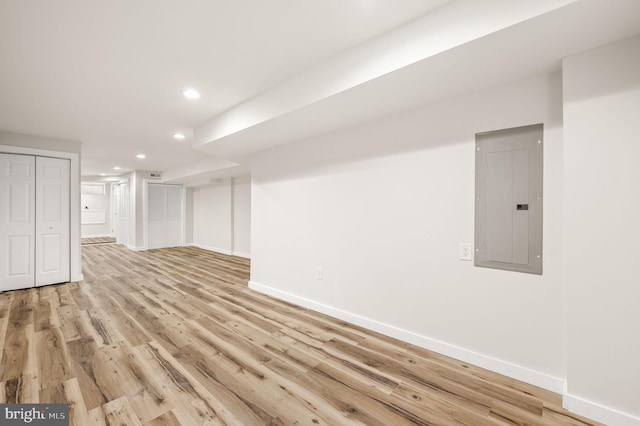 basement with electric panel and light wood-type flooring