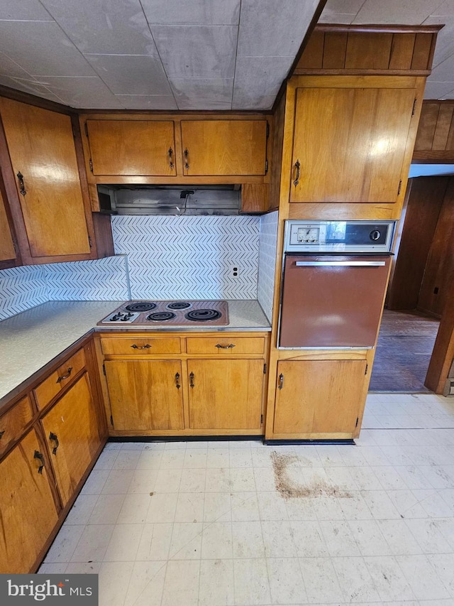 kitchen with electric cooktop, wall oven, and range hood