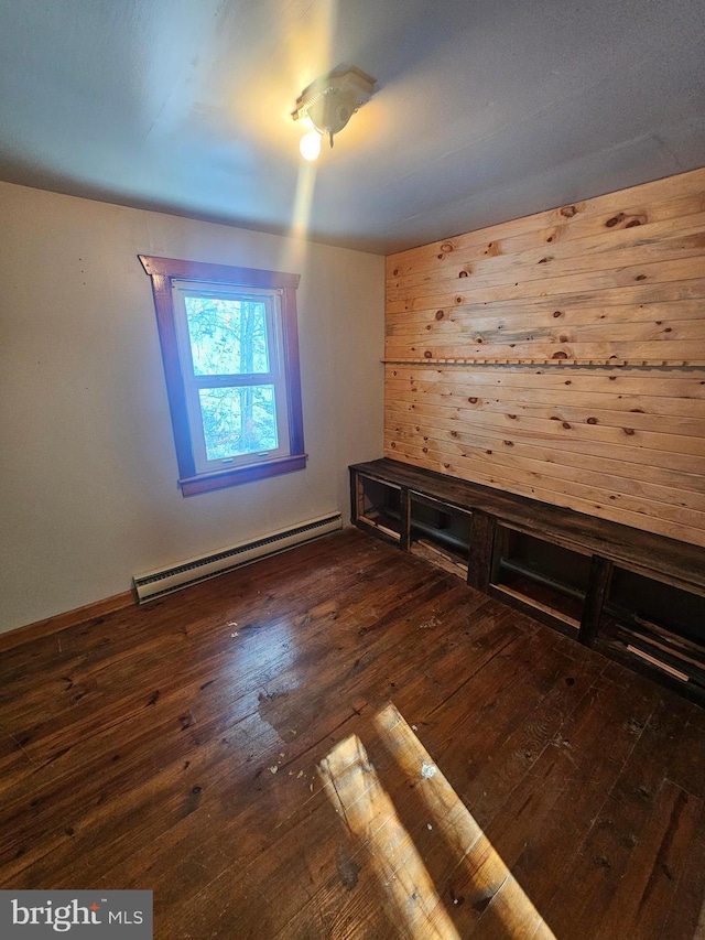 empty room featuring dark hardwood / wood-style flooring and baseboard heating