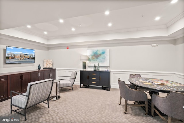 carpeted dining room featuring a tray ceiling and ornamental molding